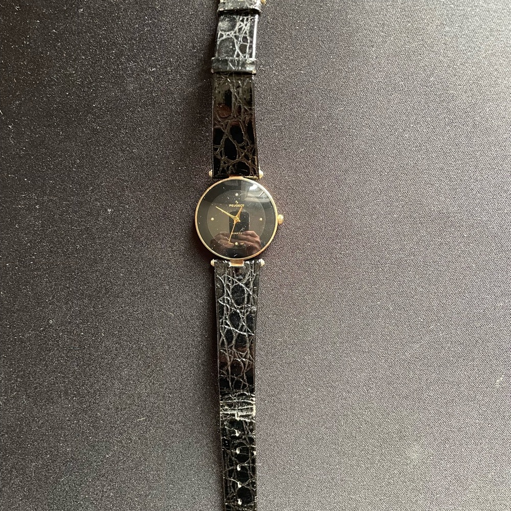 Paul Peugeot gold watch with a black dial and simulated black snakeskin band